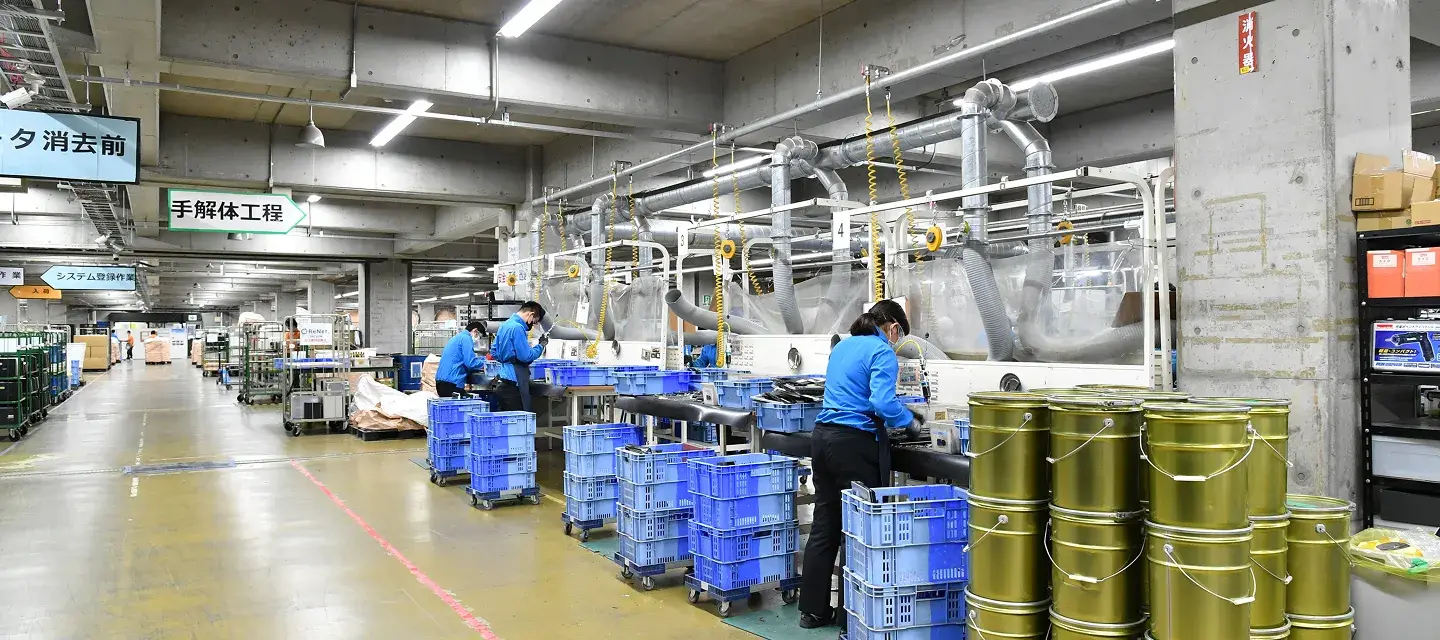 リサイクル工場の手解体工程で作業する社員