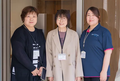 施設の入口に立つ3人の社員