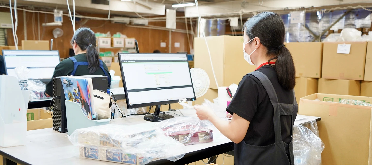 リユース倉庫でパソコンを使い商品を検品する社員